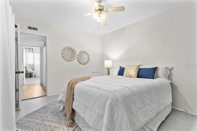 bedroom with light speckled floor, visible vents, and baseboards