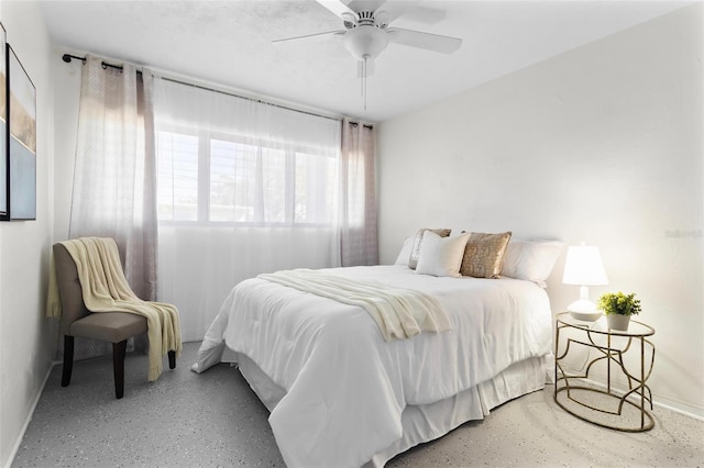 bedroom featuring concrete floors, ceiling fan, and baseboards