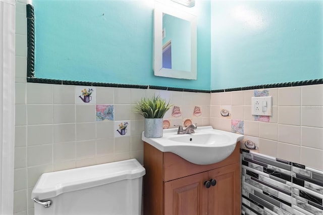 bathroom with vanity, toilet, and tile walls