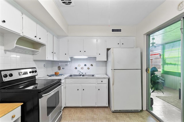 kitchen featuring stainless steel electric range oven, visible vents, freestanding refrigerator, white cabinetry, and a sink