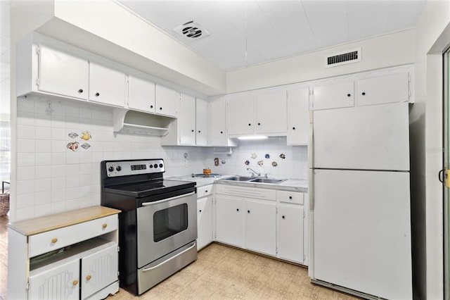 kitchen featuring light countertops, freestanding refrigerator, a sink, stainless steel range with electric stovetop, and under cabinet range hood