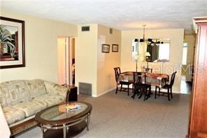 dining area with light colored carpet and a chandelier