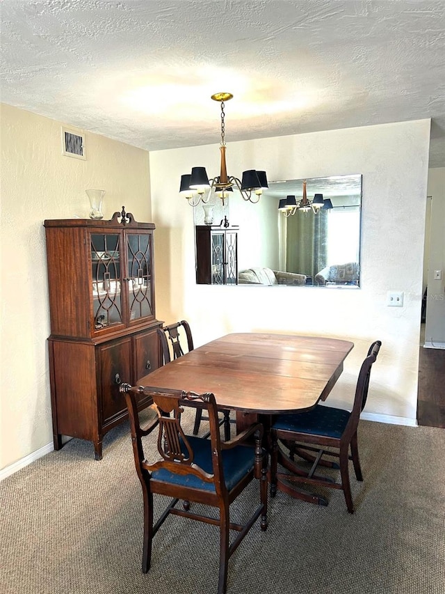 carpeted dining space with a textured ceiling and a chandelier