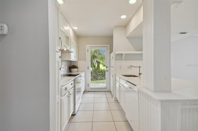 kitchen with decorative backsplash, white appliances, white cabinets, and sink