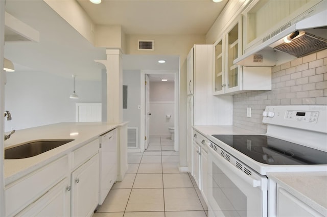 kitchen featuring sink, light tile patterned flooring, premium range hood, white appliances, and white cabinets