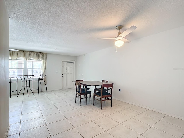 tiled dining room with a textured ceiling and ceiling fan