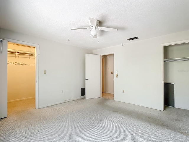 unfurnished bedroom with ceiling fan, a textured ceiling, and light carpet