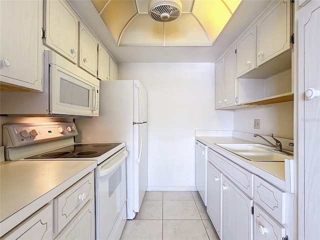 kitchen featuring sink, white appliances, light tile floors, and white cabinets