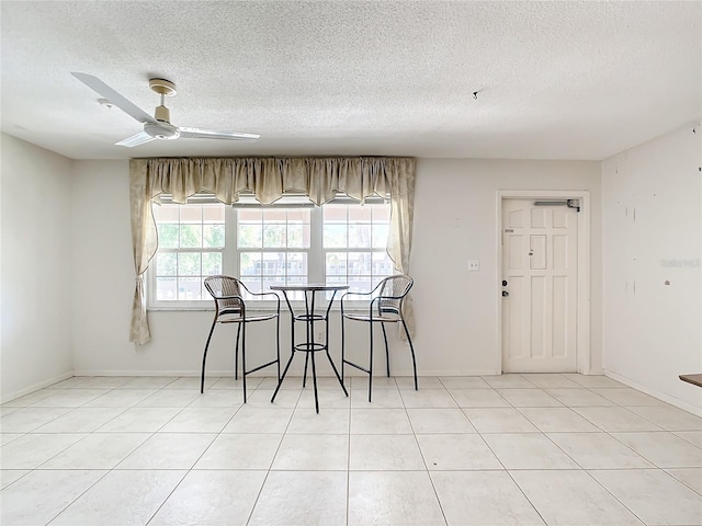 dining area with a textured ceiling, ceiling fan, and light tile flooring