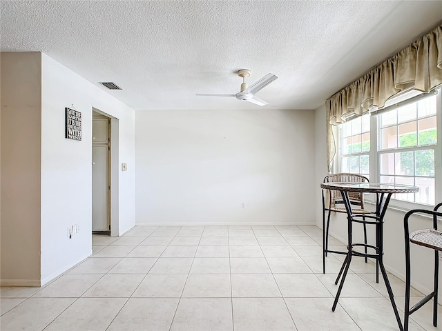 dining space featuring ceiling fan, a textured ceiling, and light tile floors