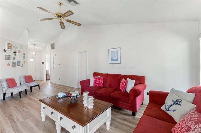 living room with light hardwood / wood-style floors, ceiling fan, and high vaulted ceiling