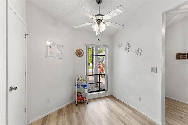 spare room featuring a textured ceiling, ceiling fan, and light wood-type flooring