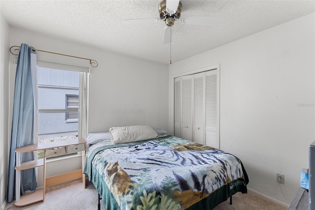 carpeted bedroom featuring ceiling fan, a textured ceiling, and a closet