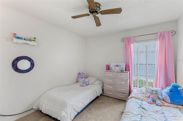 carpeted bedroom featuring a textured ceiling and ceiling fan