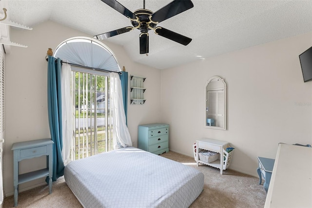 bedroom featuring ceiling fan, lofted ceiling, light colored carpet, and a textured ceiling