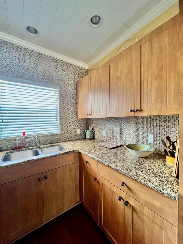 kitchen featuring ornamental molding, sink, tasteful backsplash, and light stone countertops