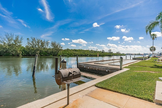 view of dock with a water view and a yard