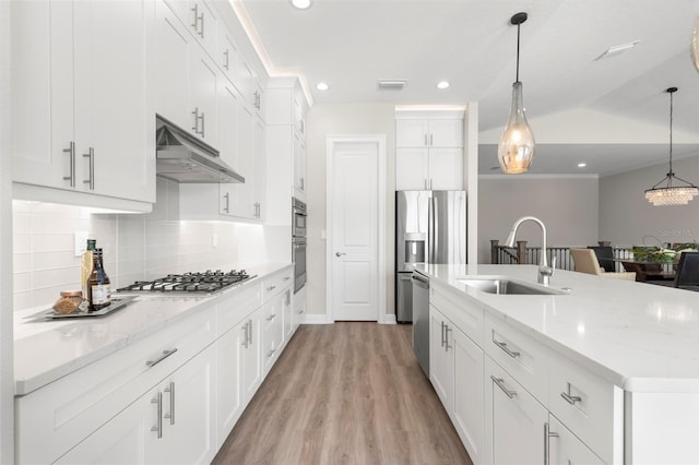 kitchen featuring white cabinetry, appliances with stainless steel finishes, a kitchen island with sink, hanging light fixtures, and sink