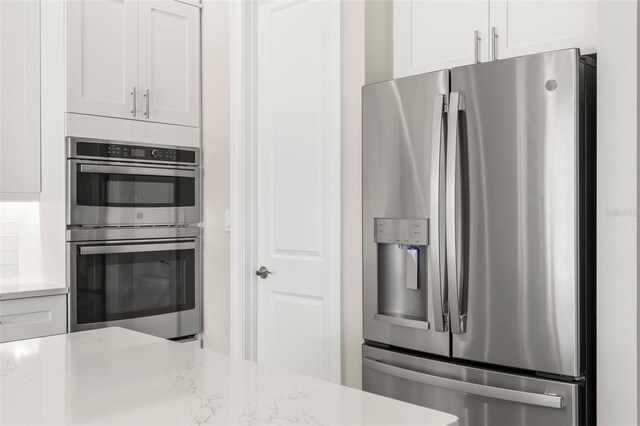 kitchen featuring light stone countertops, white cabinets, and appliances with stainless steel finishes