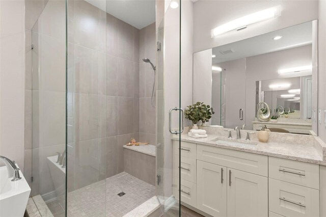 bathroom featuring vanity and independent shower and bath