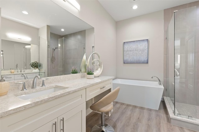 bathroom with separate shower and tub, vanity, and wood-type flooring