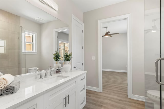 bathroom featuring toilet, ceiling fan, and a shower with door