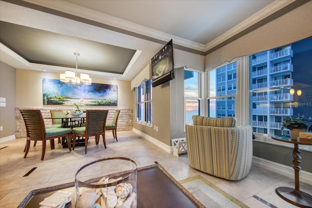 tiled dining area with a notable chandelier, a tray ceiling, and crown molding