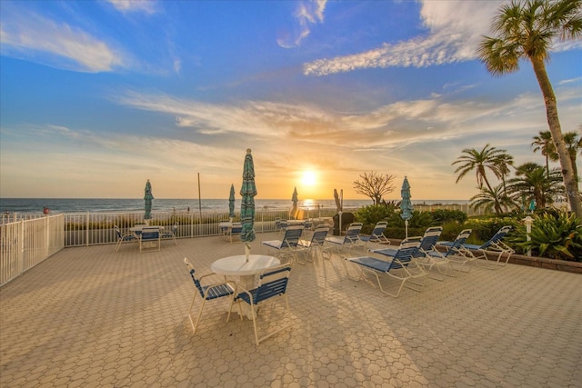 patio terrace at dusk featuring a water view