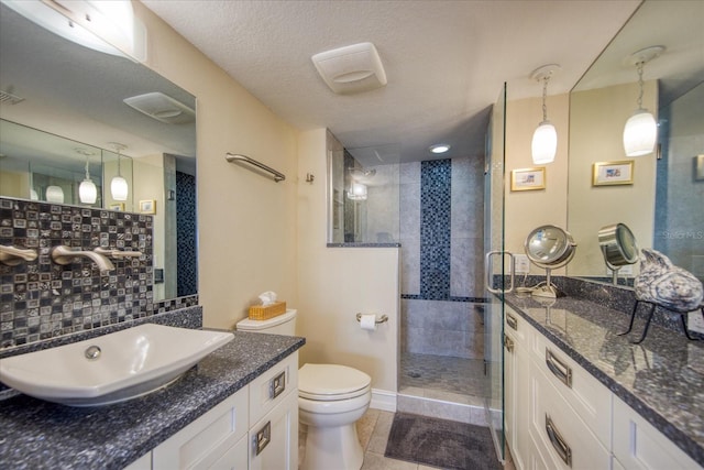 bathroom with walk in shower, tile floors, vanity, toilet, and a textured ceiling