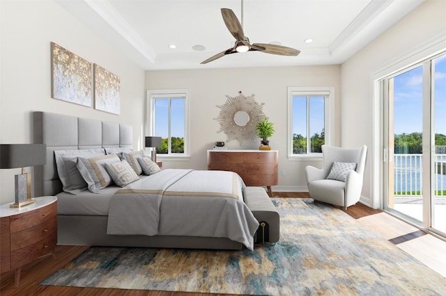 bedroom featuring access to exterior, dark hardwood / wood-style flooring, and multiple windows