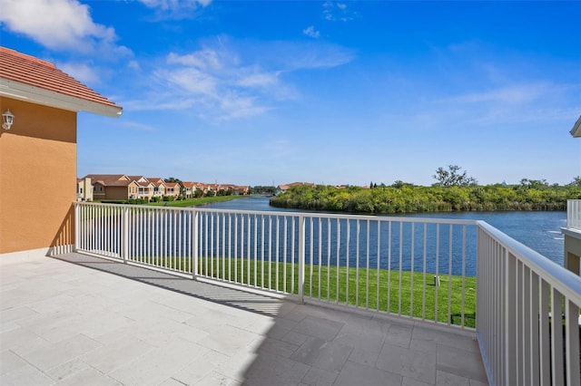 view of patio featuring a balcony and a water view