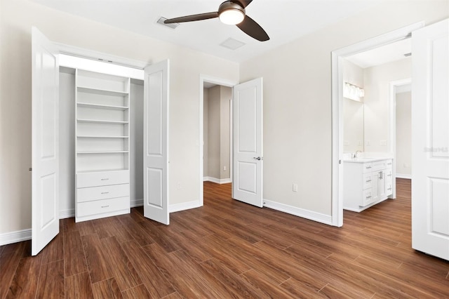 unfurnished bedroom featuring ceiling fan, sink, connected bathroom, and dark wood-type flooring