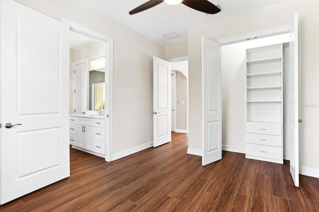 unfurnished bedroom featuring dark hardwood / wood-style flooring, ceiling fan, connected bathroom, and sink