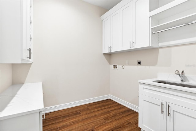 washroom with electric dryer hookup, hookup for a washing machine, sink, dark hardwood / wood-style flooring, and cabinets