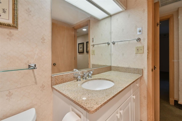 bathroom featuring toilet and large vanity