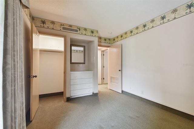 unfurnished bedroom featuring a closet and dark colored carpet