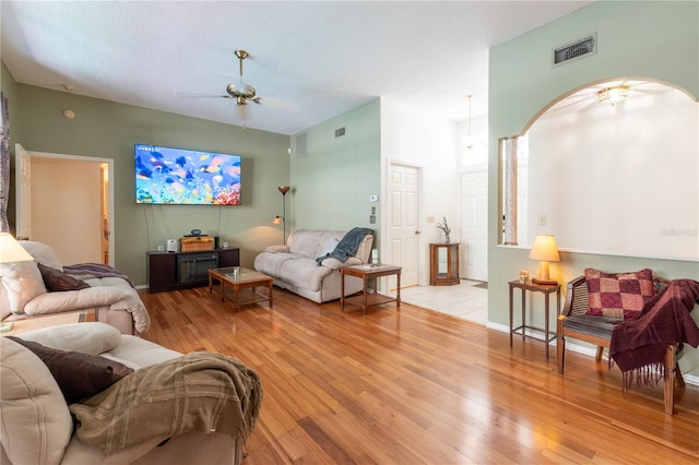 tiled living room with ceiling fan and a textured ceiling