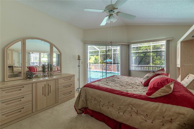 carpeted bedroom featuring ceiling fan, multiple windows, a textured ceiling, and vaulted ceiling