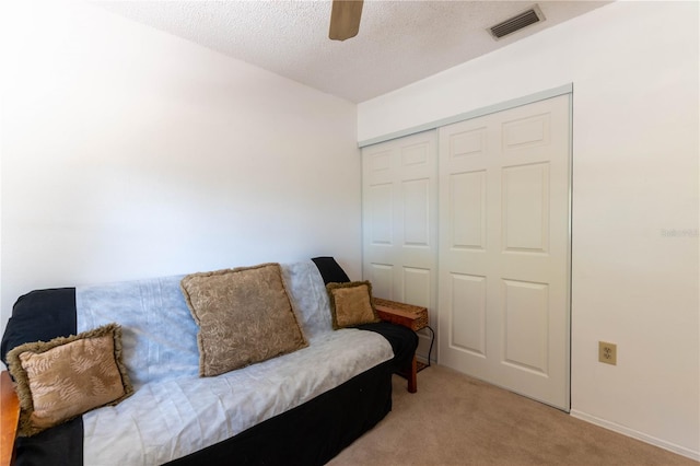 carpeted living room with a textured ceiling and ceiling fan