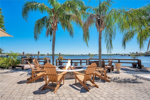 view of patio with a water view and a fire pit