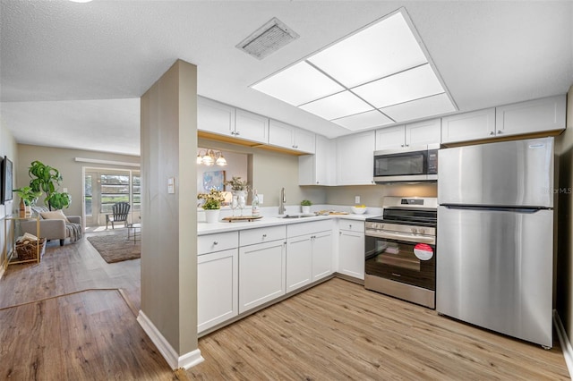 kitchen featuring white cabinets, sink, stainless steel appliances, and light wood-type flooring