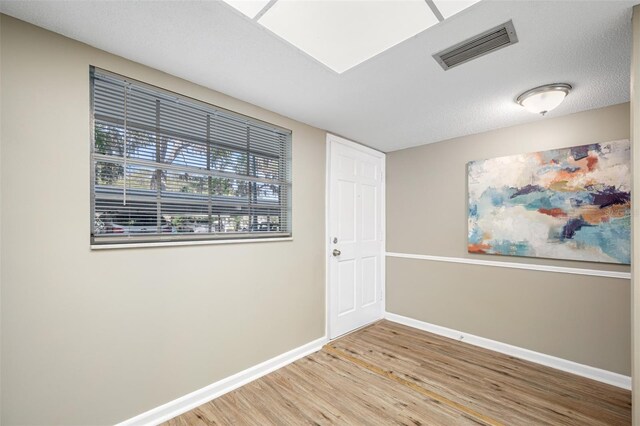 spare room with wood-type flooring and a textured ceiling