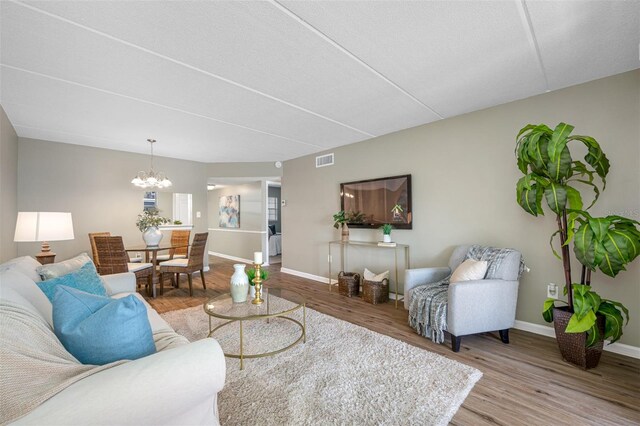 living room with hardwood / wood-style floors and a chandelier