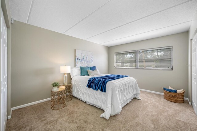 carpeted bedroom with a closet and a textured ceiling