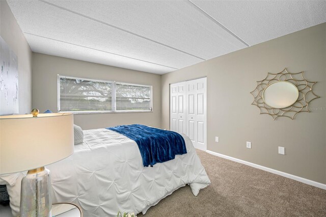 carpeted bedroom with a closet and a textured ceiling