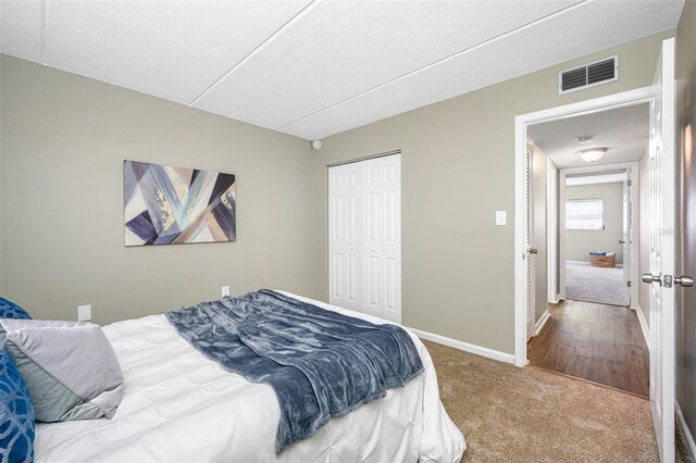 carpeted bedroom featuring a closet and a textured ceiling