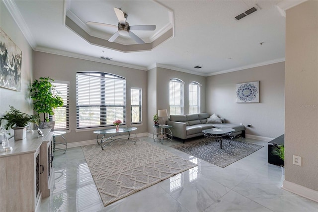 living room with a tray ceiling, ornamental molding, and ceiling fan