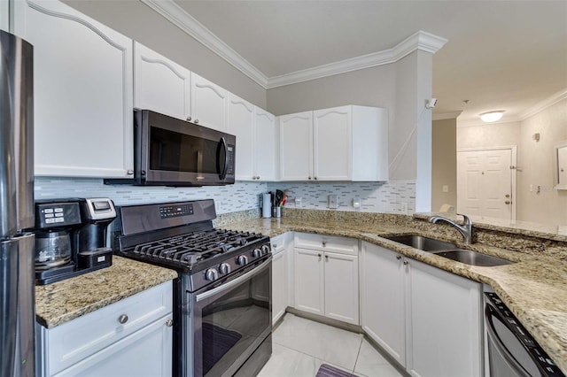 kitchen with stainless steel appliances, white cabinetry, light stone countertops, and light tile patterned flooring