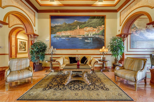 living area featuring ornate columns and crown molding