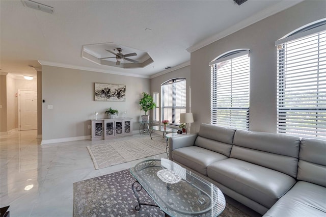 living room featuring ceiling fan, ornamental molding, and a tray ceiling